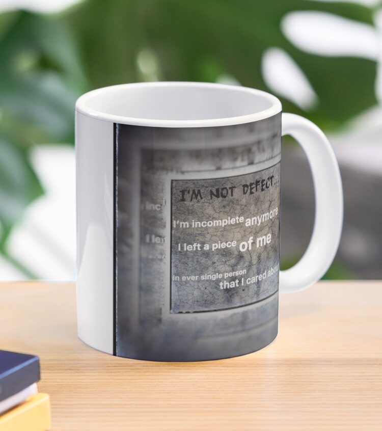 Designs by Heal of Souls White mug featuring a motivational quote on a textured grey background.